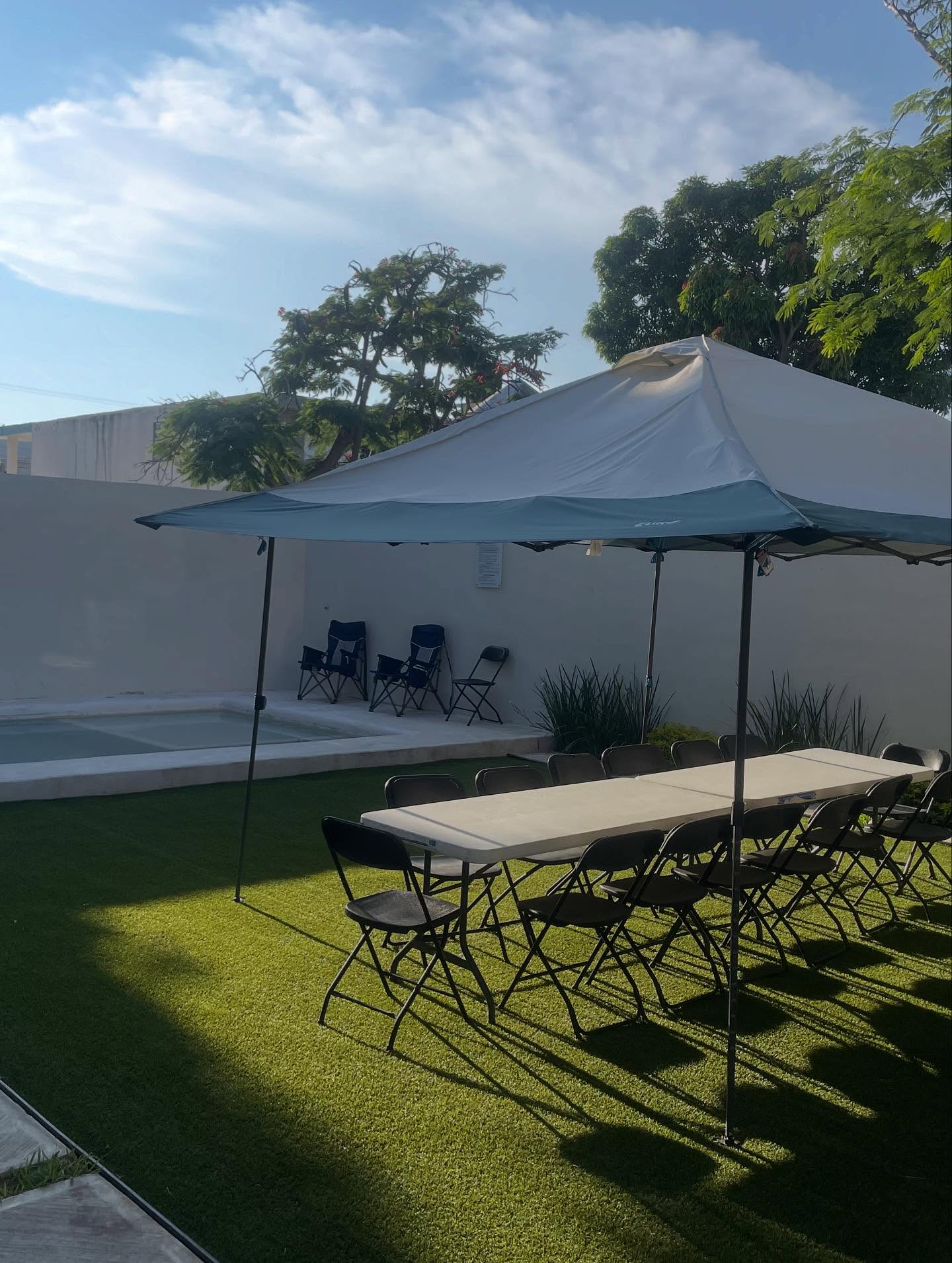 Jardín con mobiliario para reuniones junto a la alberca